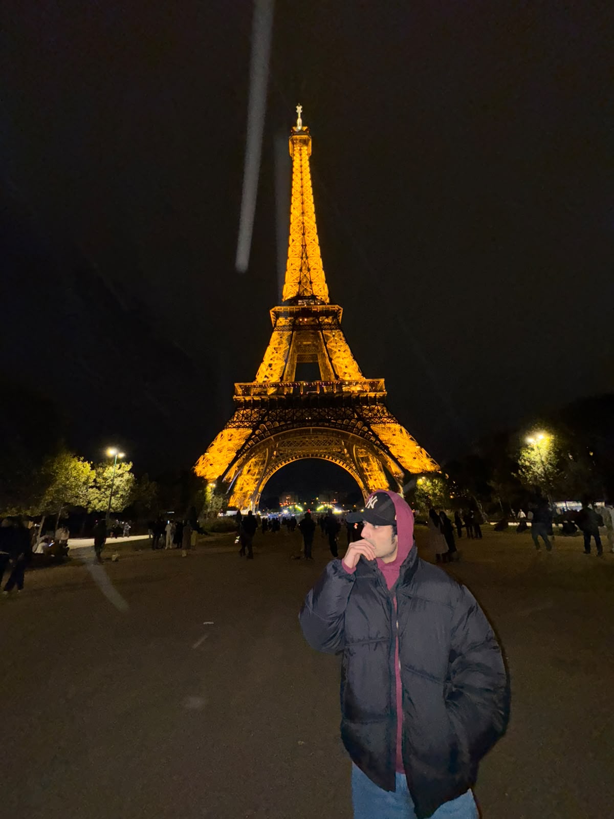 Hamya beneath the illuminated Eiffel Tower